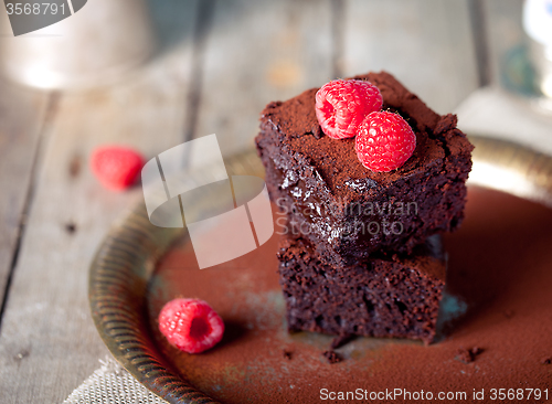 Image of Brownies with raspberry on a wooden background.