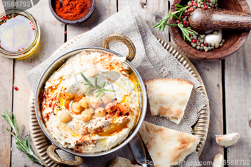 Image of Hummus, chickpea dip, with rosemary, paprika