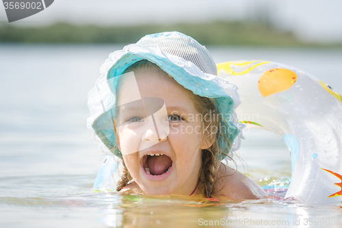 Image of Four-year girl with an open mouth with happiness bathed in the river