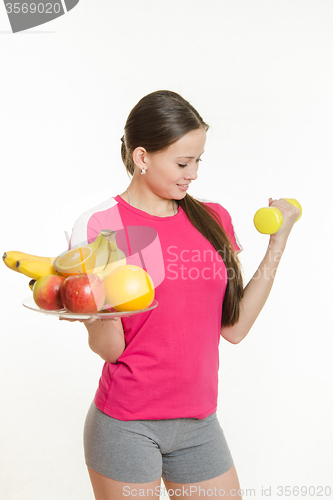 Image of Athlete swings his left hand holding a plate of fruit in his right hand