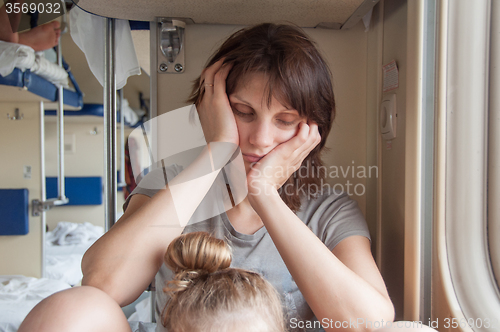 Image of Young girl asleep sitting in the second-class train carriage