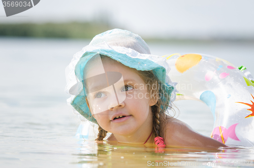Image of Thoughtful four-year girl bathes in the river