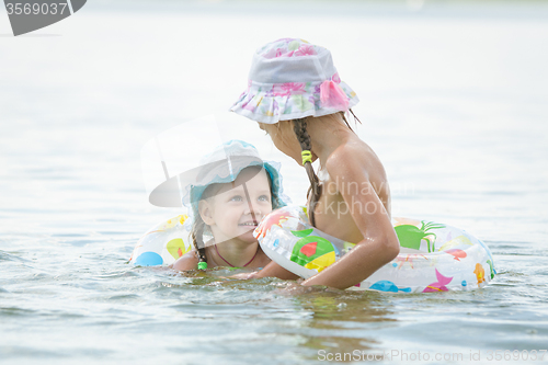 Image of Two girls are swimming in the river