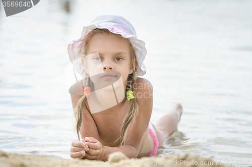 Image of The girl in panama lying on the river bank