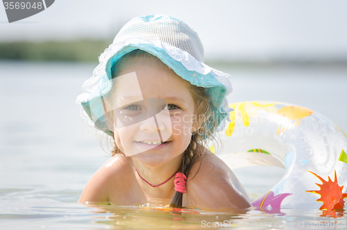 Image of Happy four-year girl bathes in the river