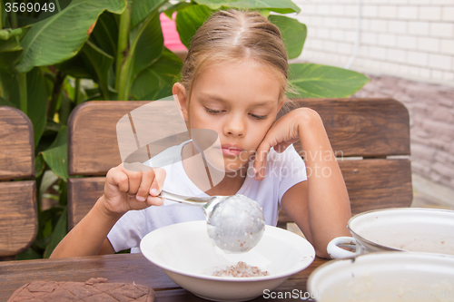 Image of Six year old girl puts his plate buckwheat