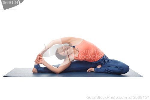 Image of Woman doing yoga asana parivrtta janu sirshasana