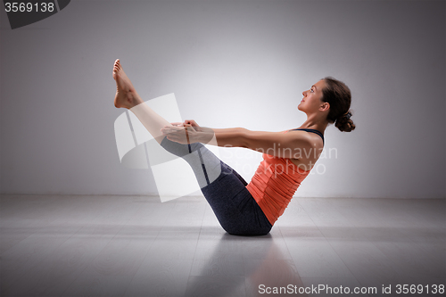 Image of Woman practices yoga asana Paripurna navasana