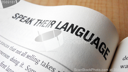 Image of Speak their language word on a book