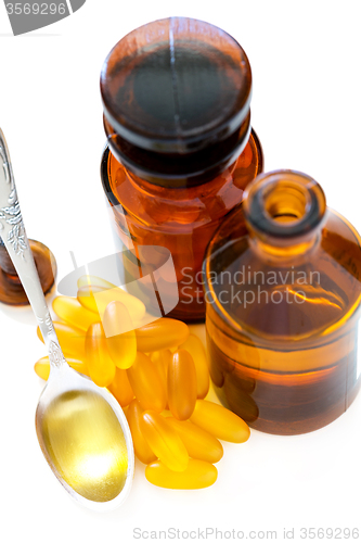 Image of Fish oil in a spoon and gel capsules.