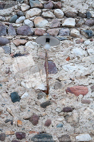 Image of Old street lamp attached to a brick wall