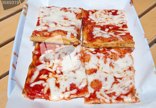 Image of Slices of pizza topped with tomato, mozzarella and olive oil