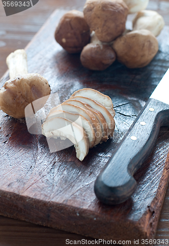 Image of 
Raw mushrooms on a wooden cutting board ready to be sliced