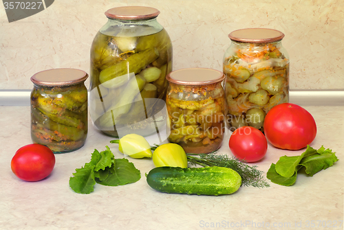 Image of Canned cucumbers with spices in glass jars.