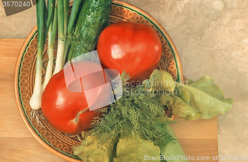 Image of Fresh vegetables: tomatoes, cucumbers, onions, lettuce.