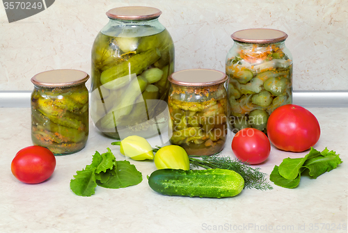 Image of Canned cucumbers with spices in glass jars.