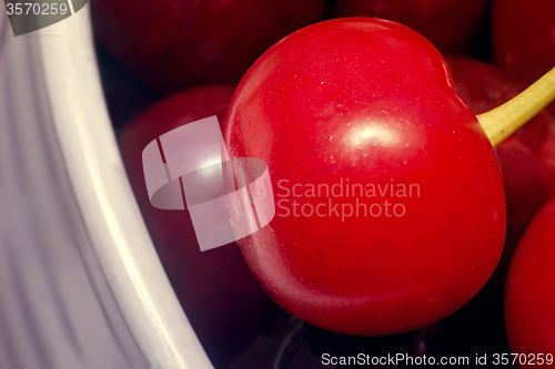 Image of Big ripe cherry in a ceramic vase.