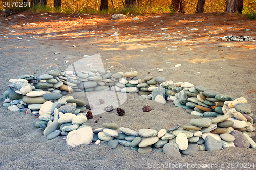 Image of Sea stones on the beach and pine cones.