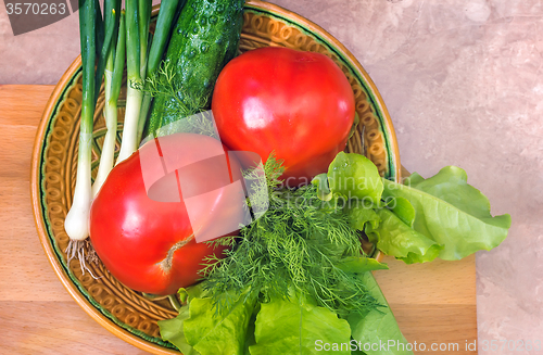 Image of Fresh vegetables: tomatoes, cucumbers, onions, lettuce.