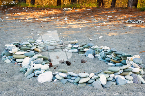 Image of Sea stones on the beach and pine cones.