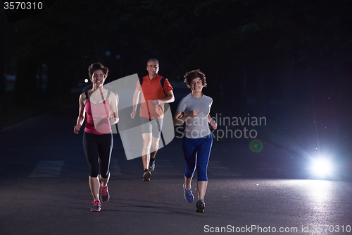 Image of people group jogging at night