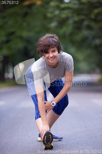 Image of woman  stretching before morning jogging