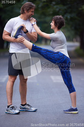 Image of jogging couple stretching