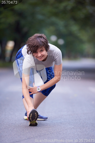 Image of woman  stretching before morning jogging