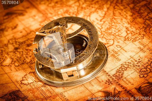 Image of Vintage compass lies on an ancient world map.