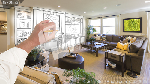 Image of Male Hand Drawing Entertainment Center Over Photo of Home Interi