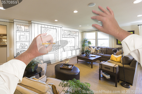 Image of Male Hands Drawing Entertainment Center Over Photo of Home Inter