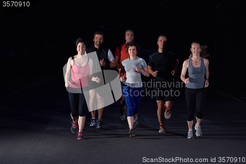 Image of people group jogging at night