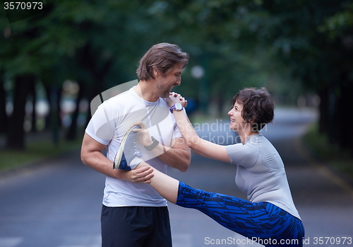 Image of jogging couple stretching