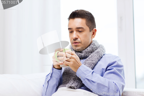 Image of ill man with flu drinking hot tea from cup at home