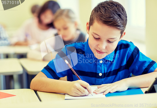 Image of group of school kids writing test in classroom