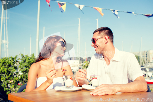 Image of smiling couple eating dessert at cafe