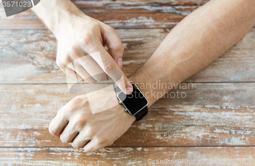 Image of close up of male hands setting smart watch