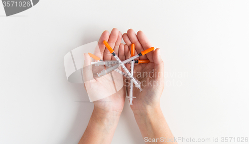 Image of close up of woman hands holding syringes
