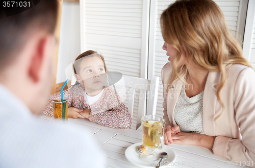 Image of happy family having dinner at restaurant or cafe