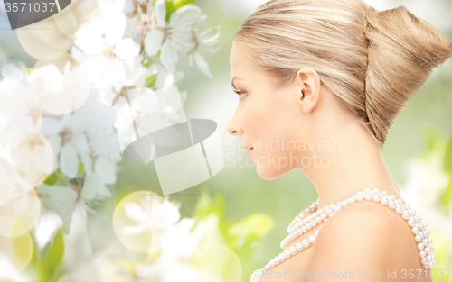 Image of woman with pearl necklace over cherry blossom