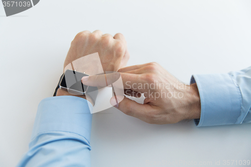 Image of close up of male hands setting smart watch