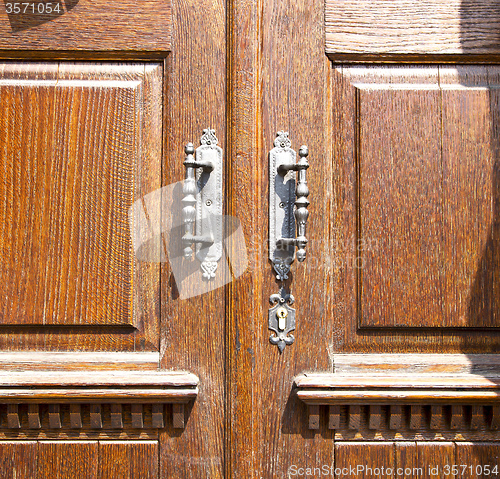 Image of  in lonate pozzolo  knocker a  door curch  closed metal wood ita