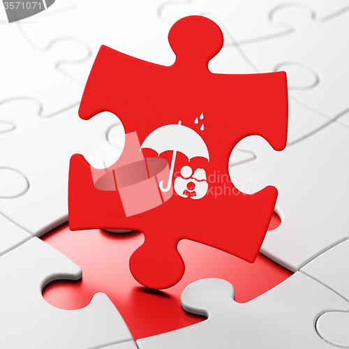 Image of Protection concept: Family And Umbrella on puzzle background