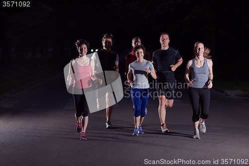 Image of people group jogging at night