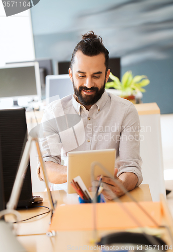 Image of happy creative male office worker with tablet pc