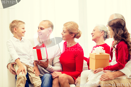 Image of smiling family with gifts at home