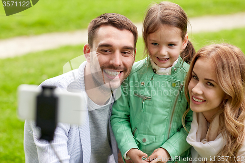 Image of happy family taking selfie by smartphone outdoors