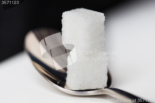 Image of close up of white sugar cubes on teaspoon