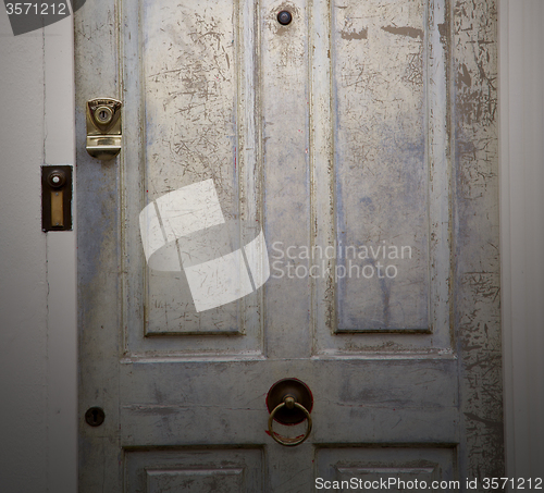 Image of handle in london antique brown door  rusty  brass nail and light