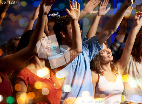 Image of smiling friends at concert in club